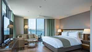 A modern hotel room with a large bed, a sofa, a small table, and a TV. - Stanford Hotel & Resort Tongyeong (Tongyeong)