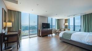 A modern hotel room with a large bed, a desk, a television, and a view of the city. - Stanford Hotel & Resort Tongyeong (Tongyeong)