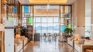 A spacious lobby with a reception desk, seating area, and a view of the sea. - Stanford Hotel & Resort Tongyeong (Tongyeong)