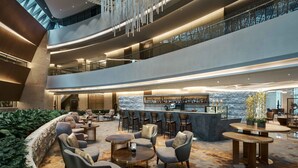 A multi-level lobby with seating areas, a bar, and a staircase. - PRIMUS Hotel Shanghai Hongqiao (Shanghai)