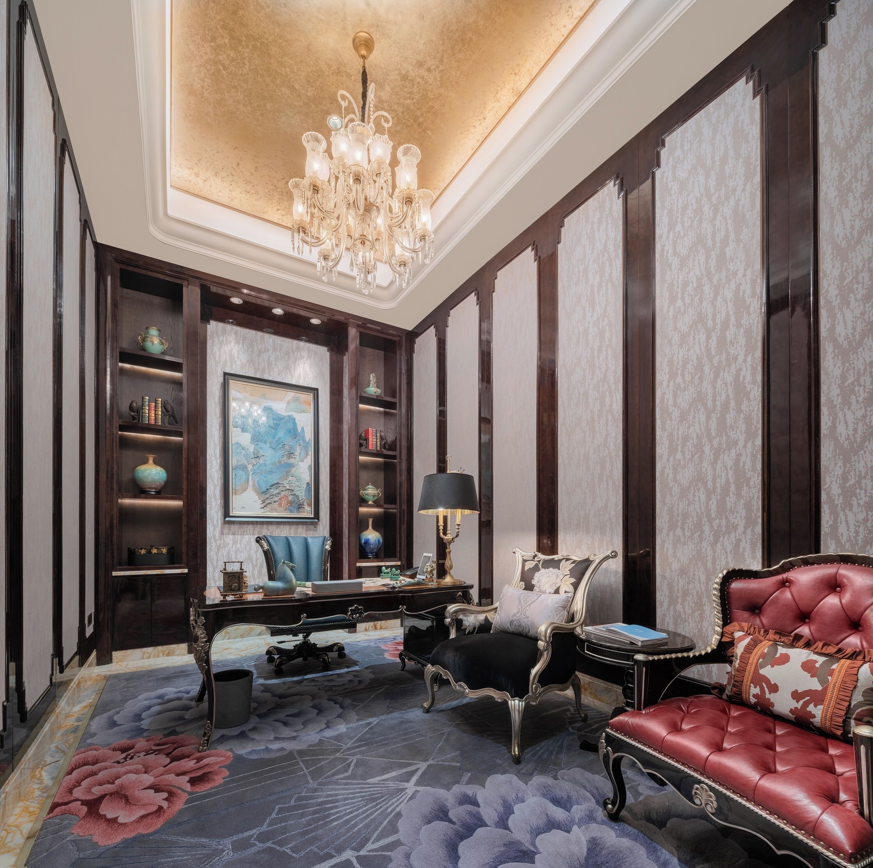 A luxurious room with a chandelier, a large painting, a desk with a lamp, and a plush sofa.