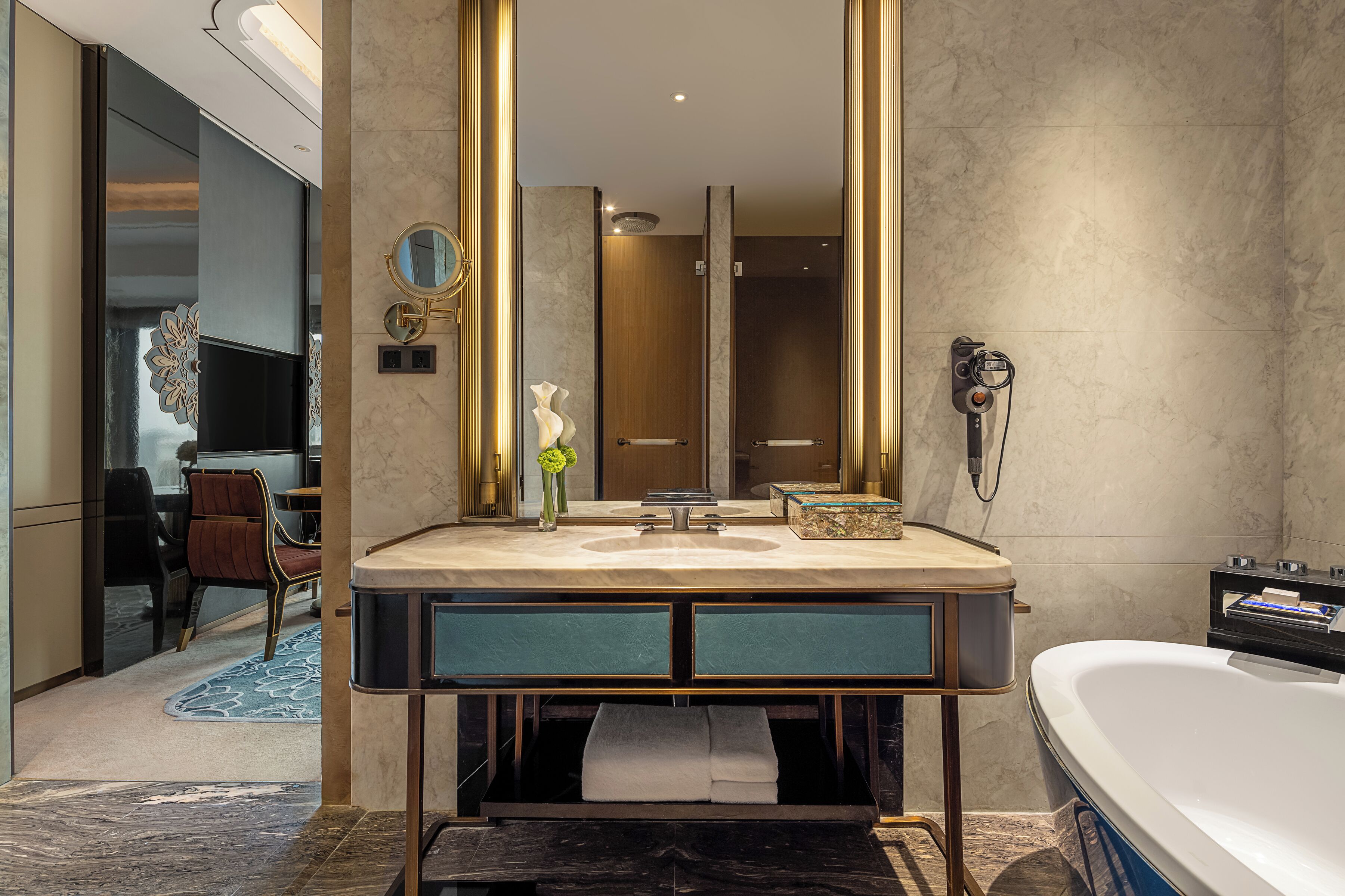 A modern bathroom with a large mirror, a bathtub, and a vanity with a sink.