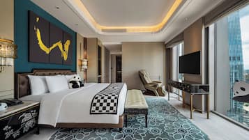 Una habitación de hotel moderna con una cama grande, una silla de masaje, un televisor y vistas a la ciudad.