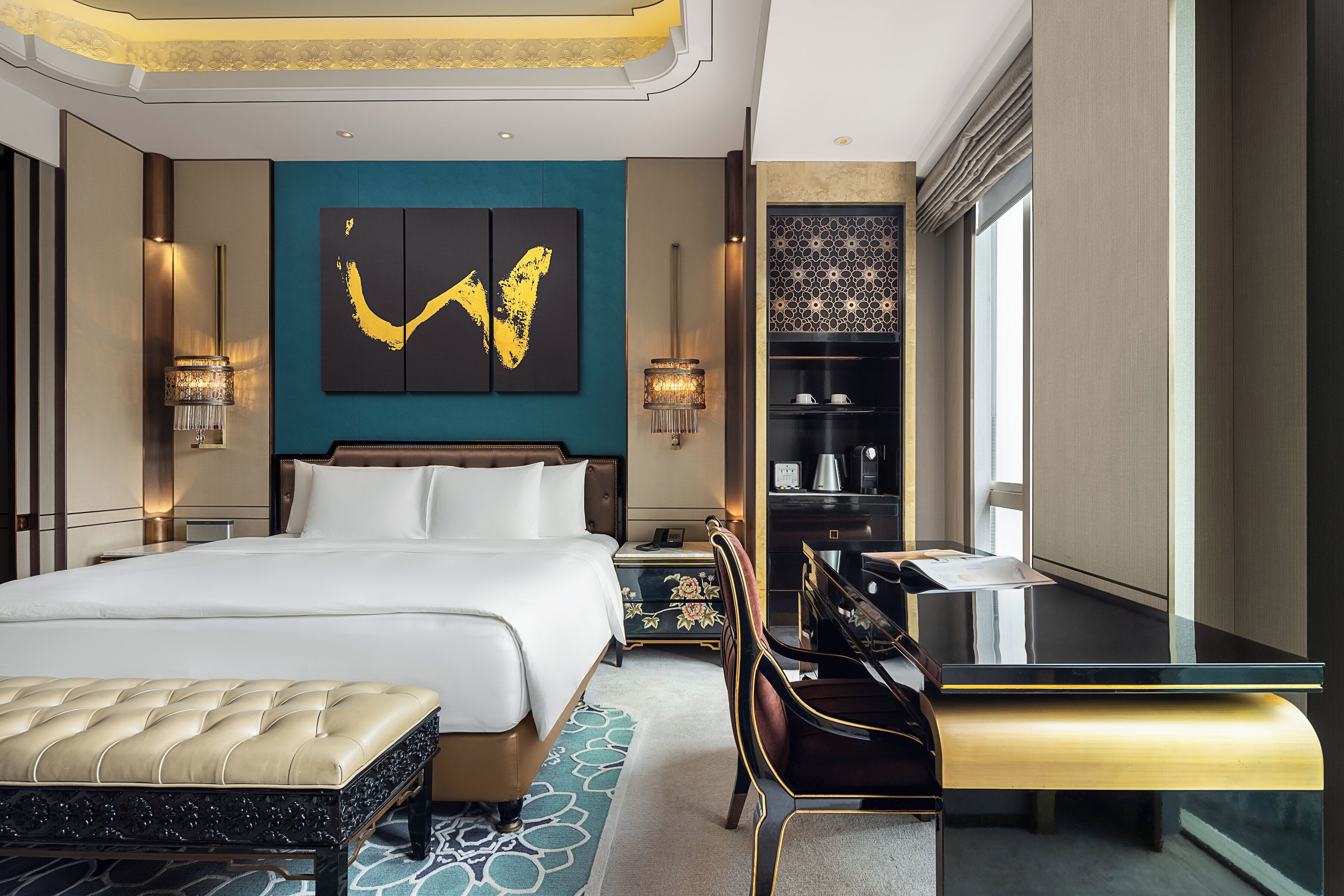 Une chambre d’hôtel avec un grand lit, un bureau, une chaise, une bibliothèque et une œuvre d’art murale.