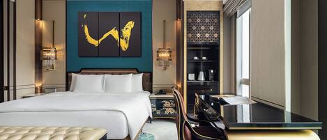 Une chambre d’hôtel avec un grand lit, un bureau, une chaise, une bibliothèque et une œuvre d’art murale.
