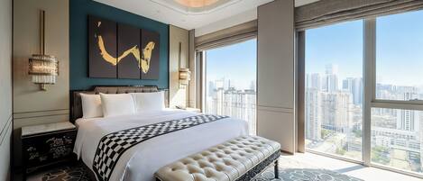 A modern hotel room with a large bed, a bench, and a city view.