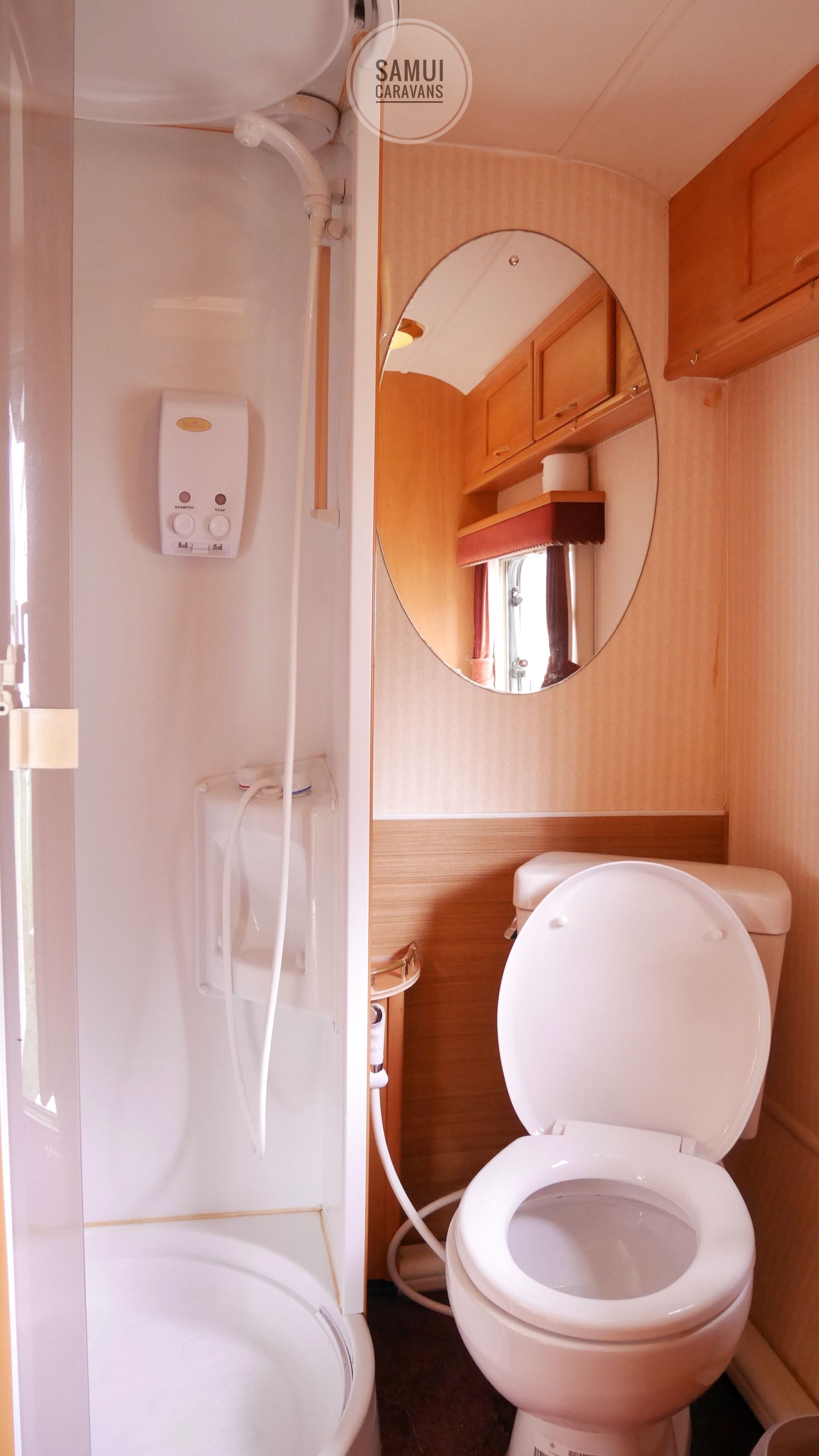 A compact bathroom with a toilet, a sink, and a mirror.