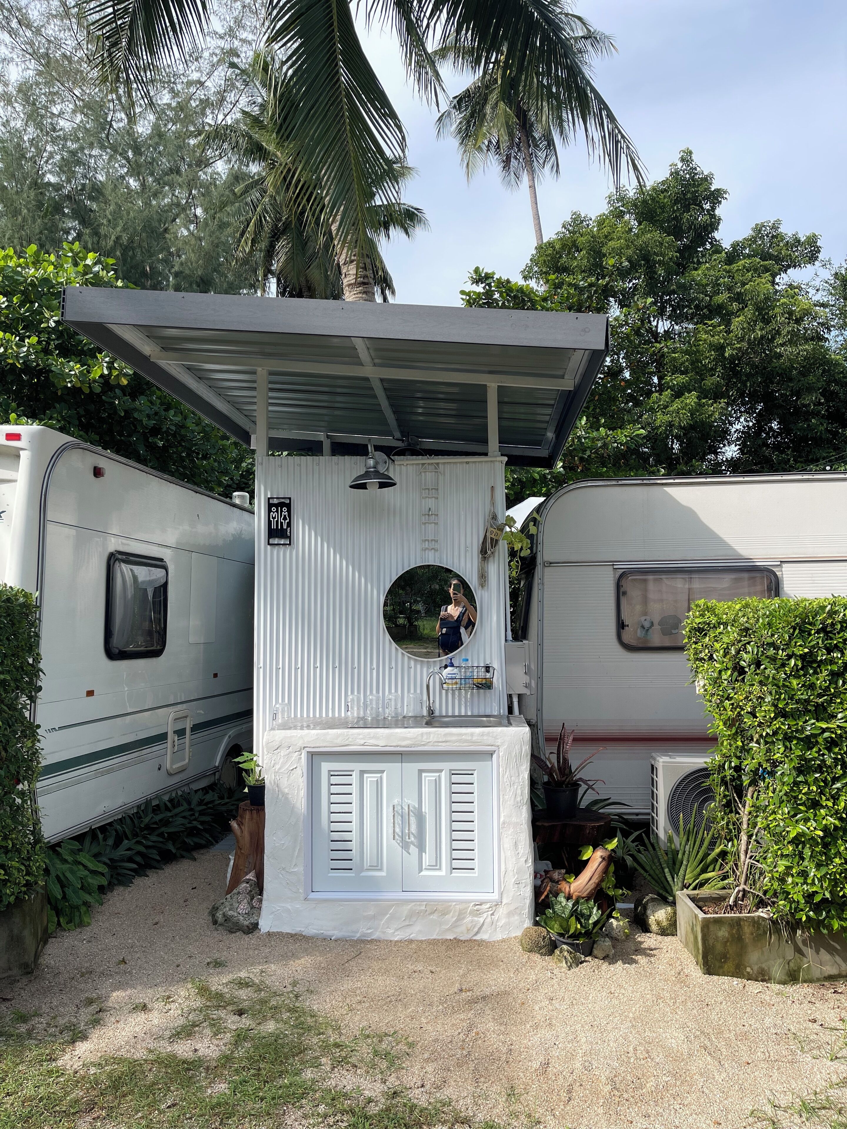 Ein tragbares Badezimmer für Wohnmobile, ausgestattet mit Waschbecken, Spiegel und Toilette.