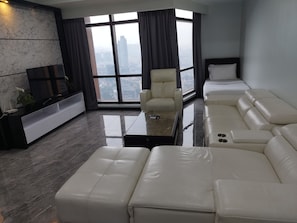 Una sala de estar moderna con un sofá grande, una mesa de centro y un televisor.
