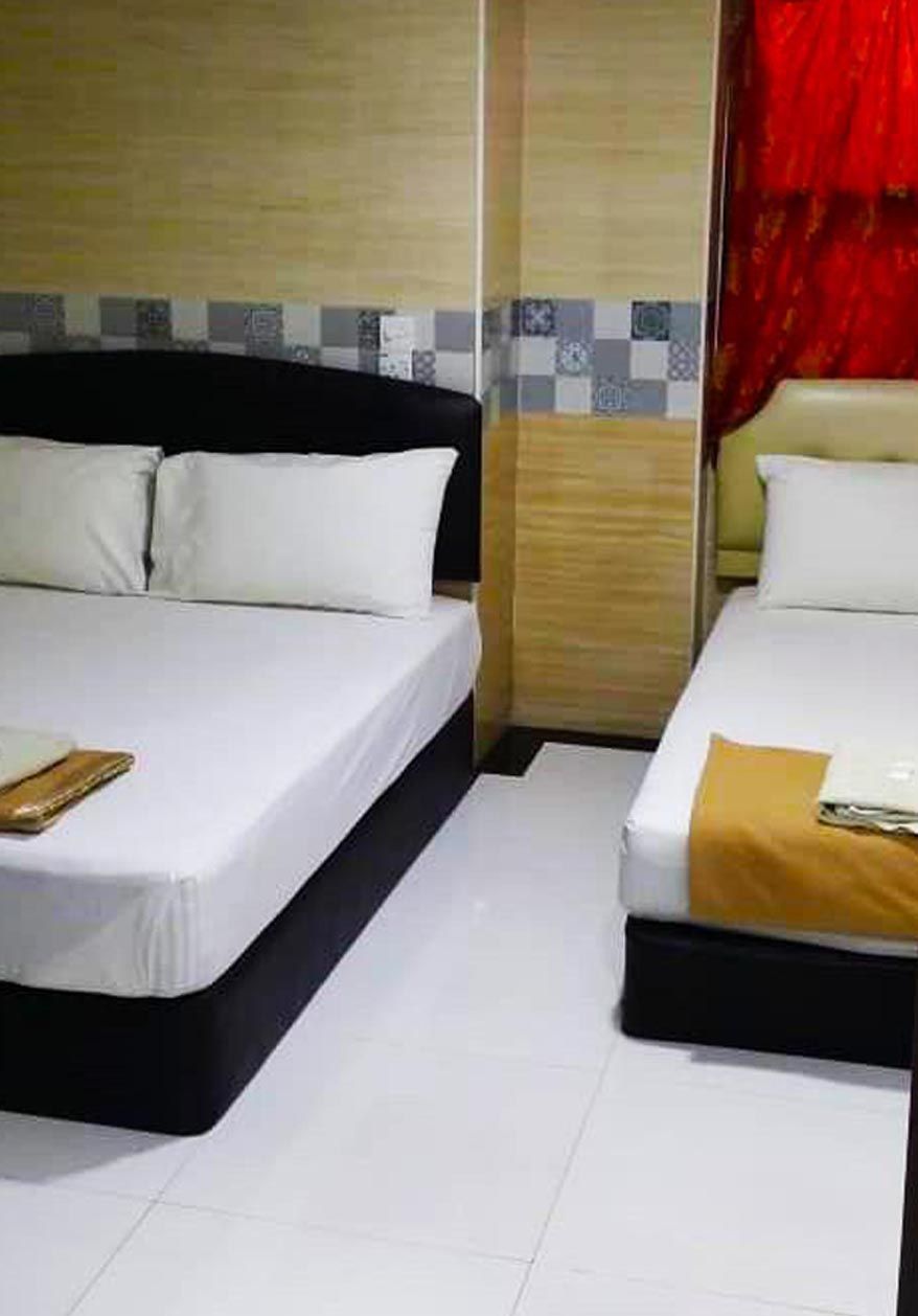 Une chambre d’hôtel avec deux lits, une tête de lit en bois, un pare-feu en carrelage et un rideau rouge.