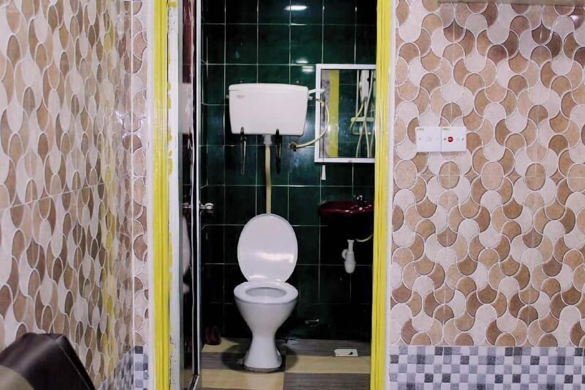 Une salle de bain avec des toilettes, un lavabo et un miroir.