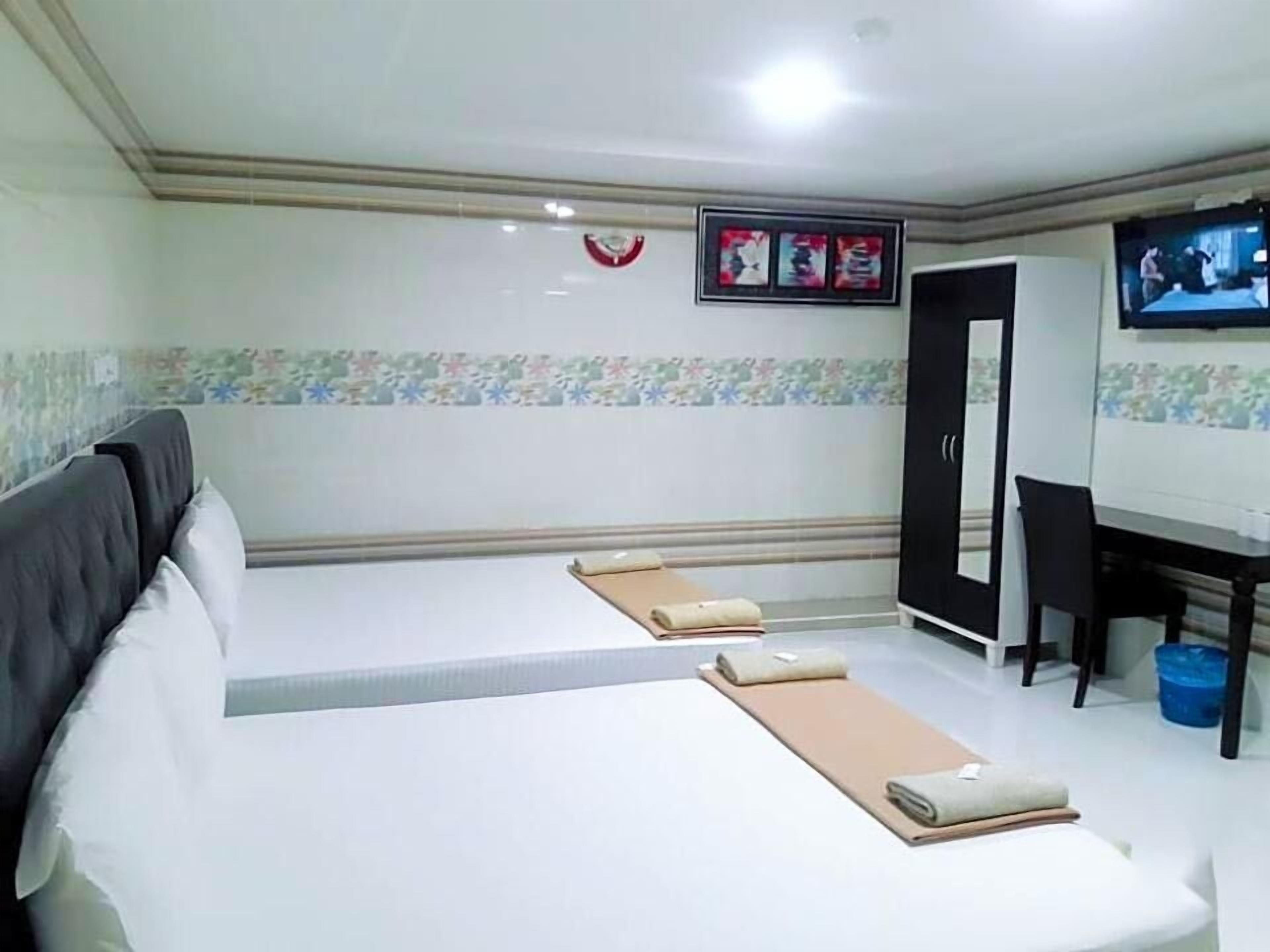 A hotel room with a bed, a desk, a television, and a bathroom.