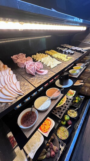 A buffet with various food items including sliced meats, vegetables, and dips. - Metropolis Suites Bangkok, Tapestry Collection by Hilton (Bangkok)