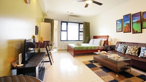 A well-lit hotel room with a bed, a sofa, a desk, and a ceiling fan. - Serena's House - Manila (Manila)