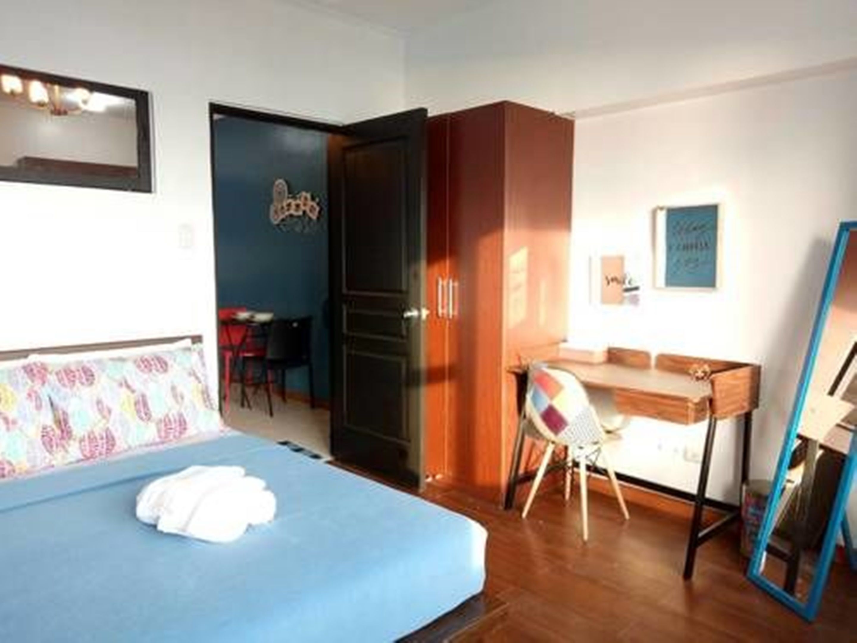 A bedroom with a bed, a desk, and a chair.