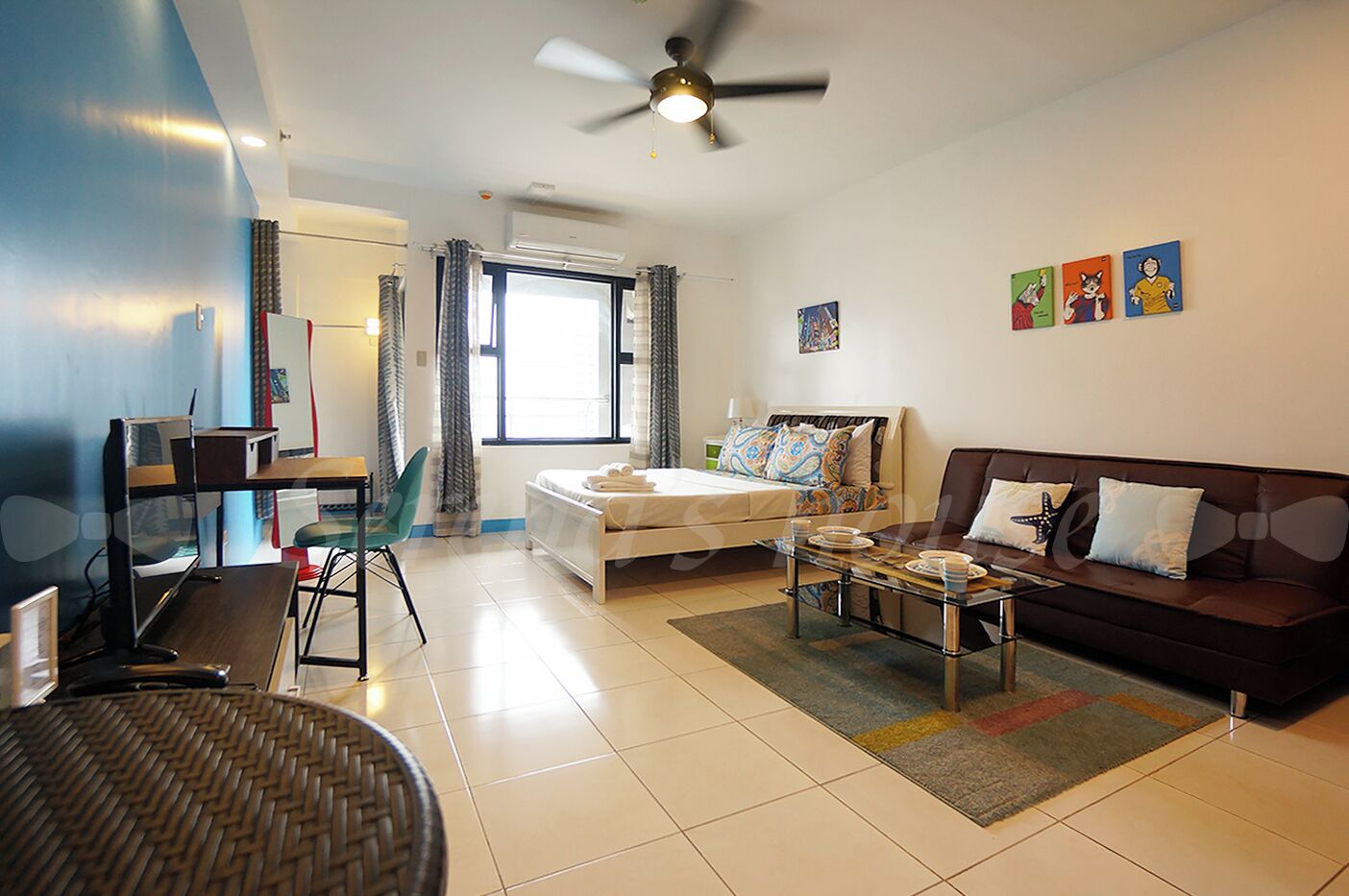 Una habitación de hotel moderna con cama, sofá, escritorio y una silla.
