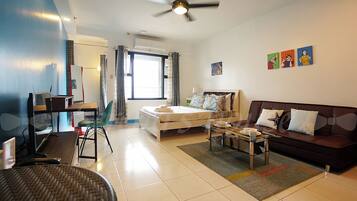 Una habitación de hotel moderna con cama, sofá, escritorio y una silla.