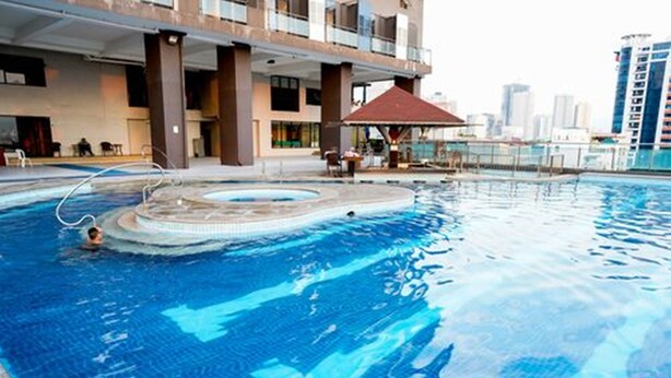 A swimming pool with a hot tub, a covered seating area, and a view of a cityscape. - Serena's House - Manila (Manila)