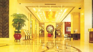 A hotel lobby with a polished marble floor, a reception desk, and a large decorative plant. - Shunde Grandview Hotel (Foshan)