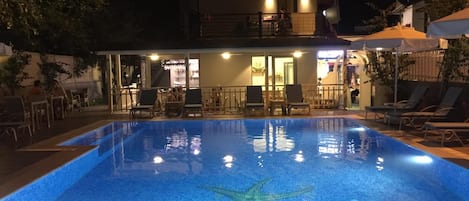Una piscina al aire libre, sombrillas, tumbonas
