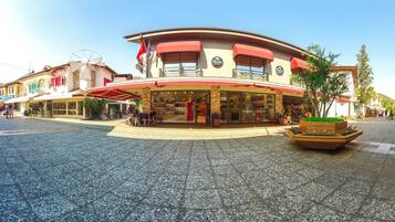 A hotel with a central atrium, outdoor seating, and a small garden area.