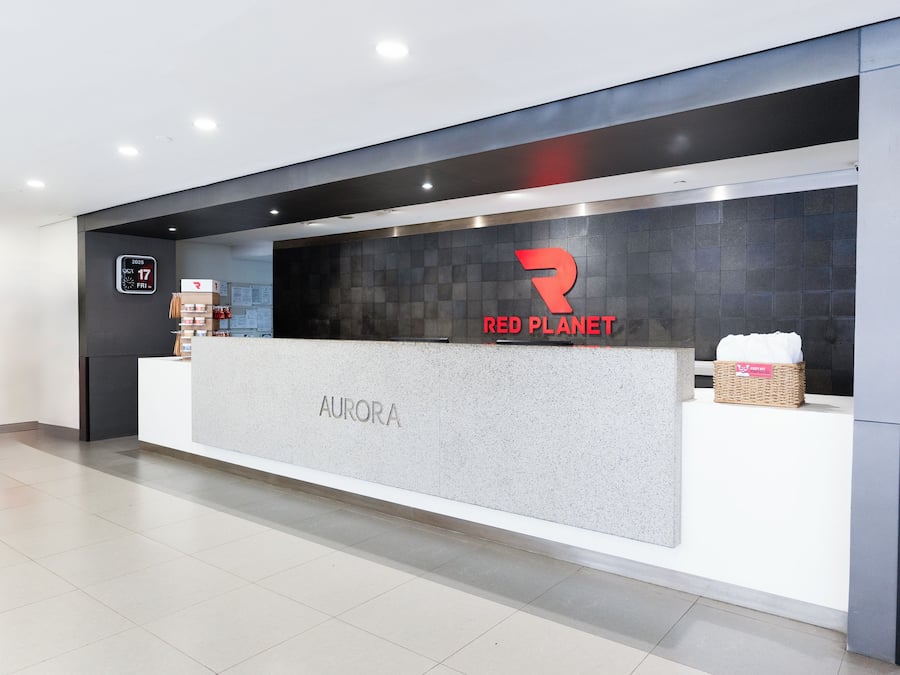A reception desk with a 'RED PLANET' logo and 'AURORA' signage.