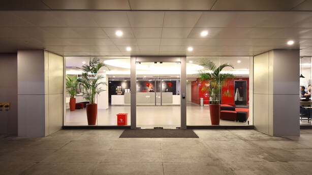 A modern hotel lobby with a reception desk, seating area, and potted plants. - Red Planet Cubao Aurora Boulevard (Quezon City)