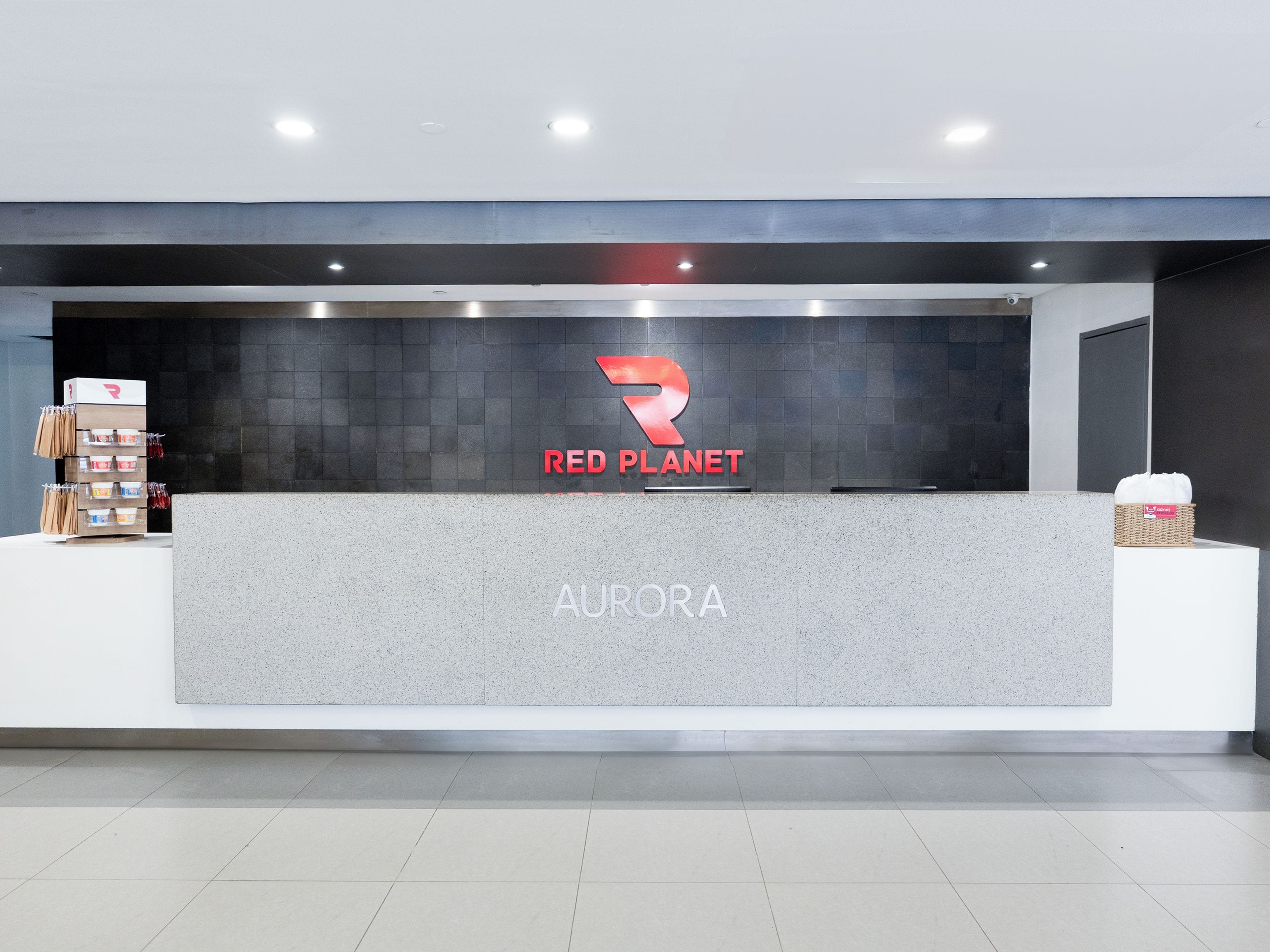 Een receptiebalie met een logo voor Red Planet en de naam Aurora.
