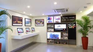 A reception area with a white counter, framed pictures on the wall, a large potted plant, and a blackboard with motivational quote. - Red Planet Cubao Aurora Boulevard (Quezon City)