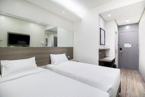 A hotel room with two beds, a large mirror, a TV, a desk, and a door. - Red Planet Cubao Aurora Boulevard (Quezon City)