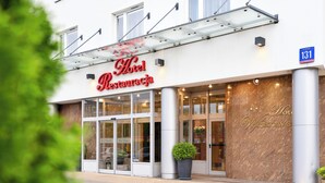 Ein Hotel Eingang mit Glasüberdachung, einem großen Blumentopf und einem Schild mit der Zimmernummer 131.