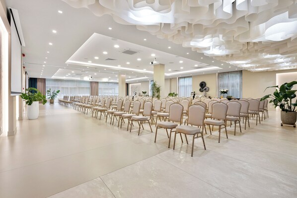 A spacious hall with rows of chairs and potted plants, featuring a modern ceiling design and large windows. - Hotel Witkowski (Warsaw)