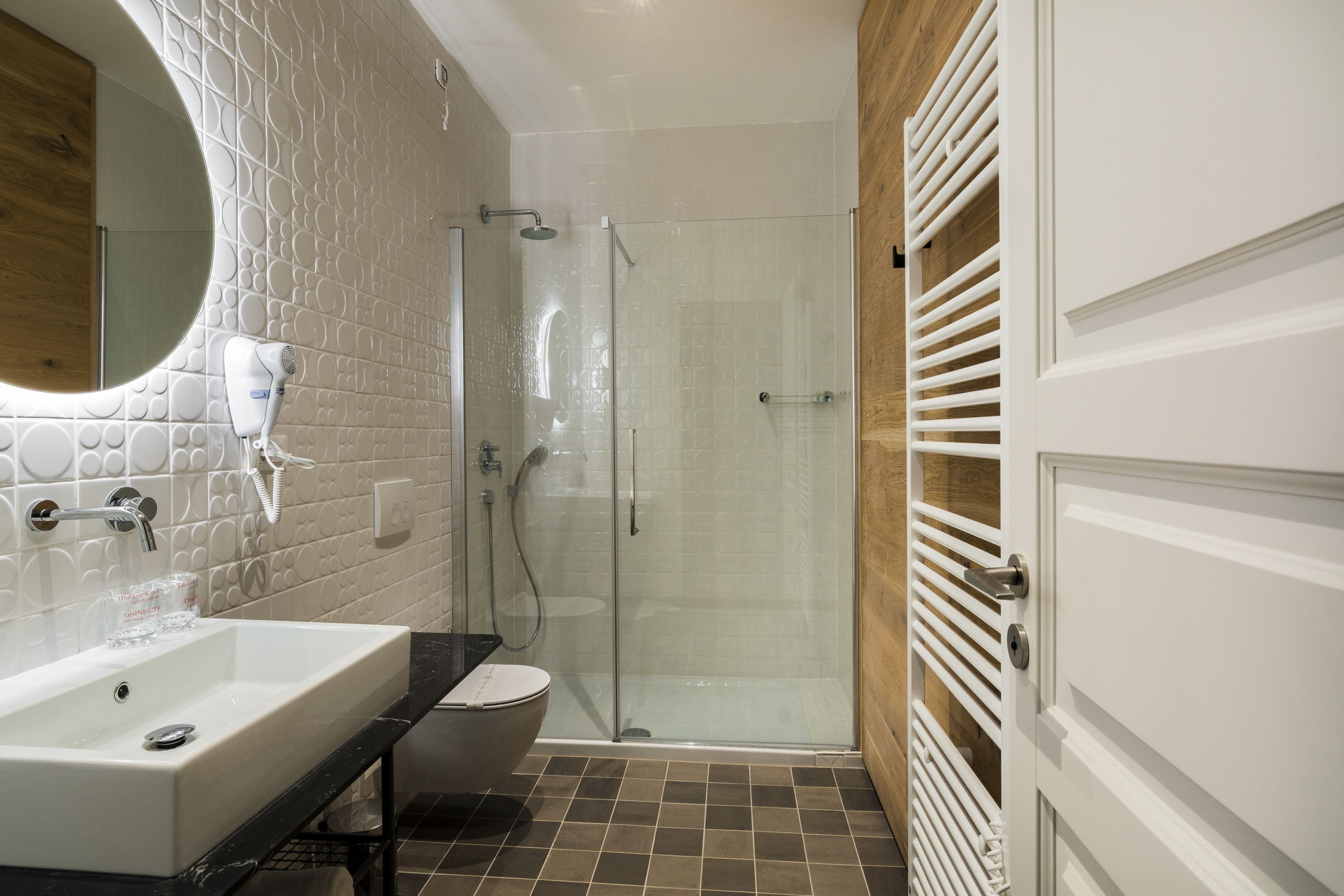 A modern bathroom with a large sink, toilet, and glass shower enclosure.