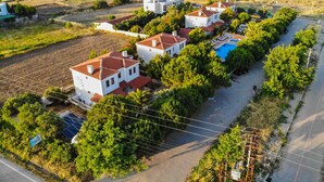 A residential area with white houses, a swimming pool, and a road. - Destina Suit Hotel (Bozcaada)