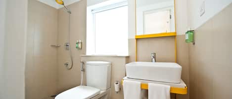 A bathroom with a toilet, bidet, sink, and mirror.