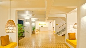 A modern hotel lobby with a chevron-patterned floor, a reception desk, and a staircase. - Bloom Hotel – Calangute (Calangute)