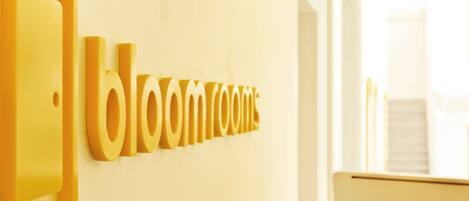 Una pared con el texto "bloomroom" en letras grandes y amarillas.