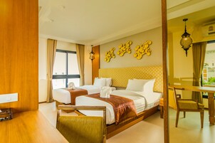 A hotel room with a large bed, two bedside tables, a desk, and a chair.