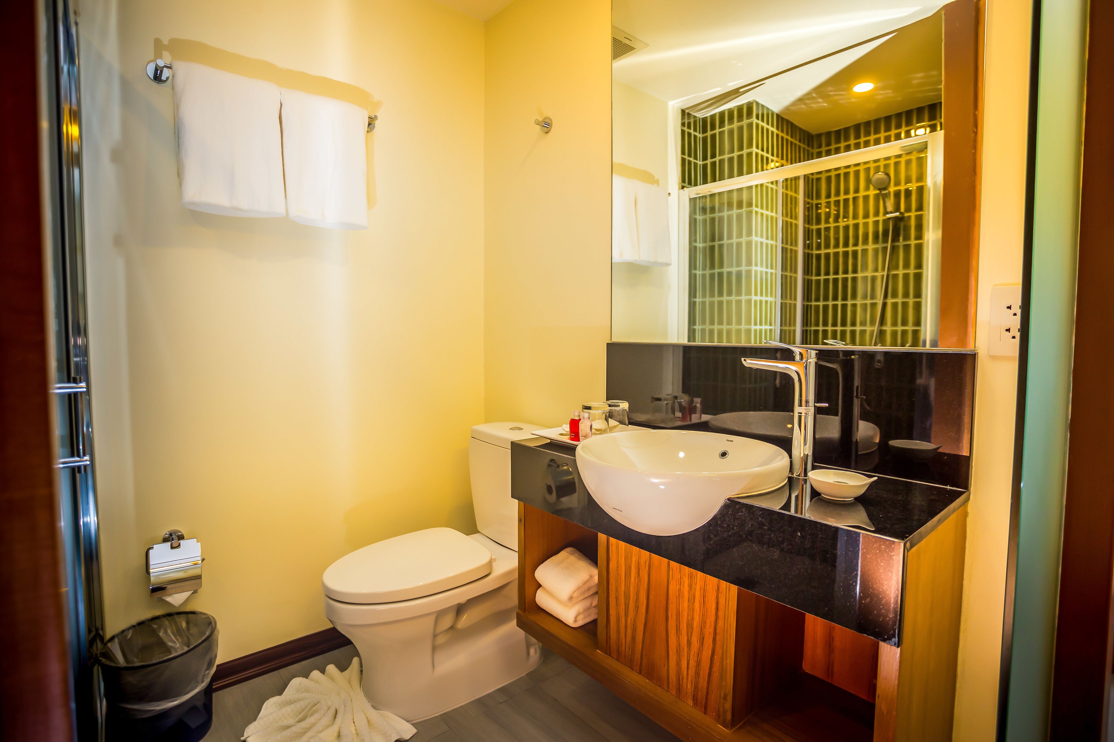 A bathroom with a toilet, sink, and mirror.