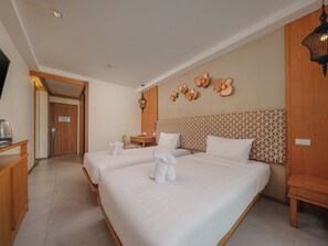 Habitación de hotel con dos camas, un escritorio, una silla y un adorno en la pared.