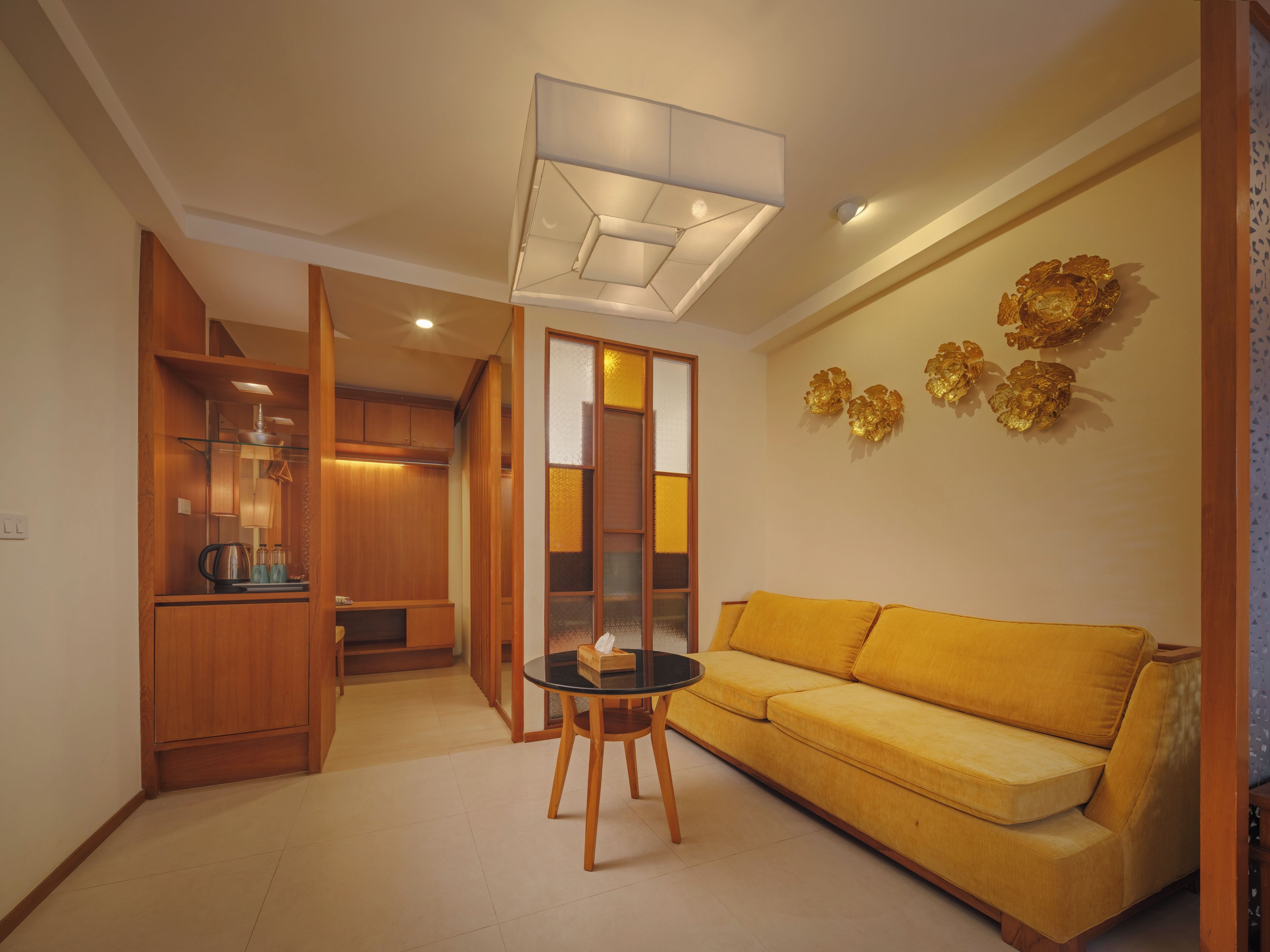 Una sala moderna con un sofá amarillo, una mesa de centro de vidrio y un mueble de madera.