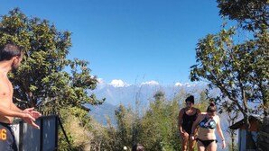Un grupo de personas en una piscina con montañas al fondo.