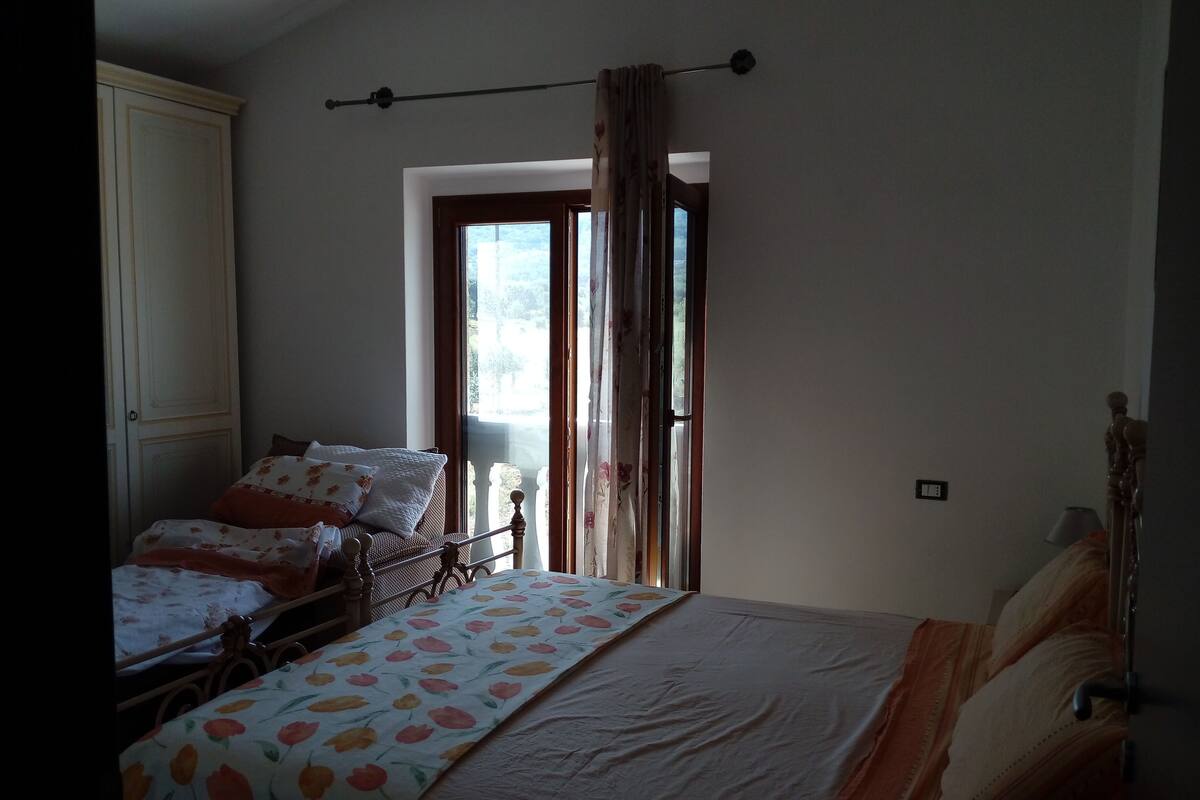 Une chambre avec deux lits, une fenêtre avec des rideaux et une vue sur l’extérieur.