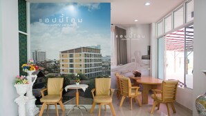 Quarto de hotel com varanda e vista para a paisagem urbana, com um letreiro 'Happy Home'.