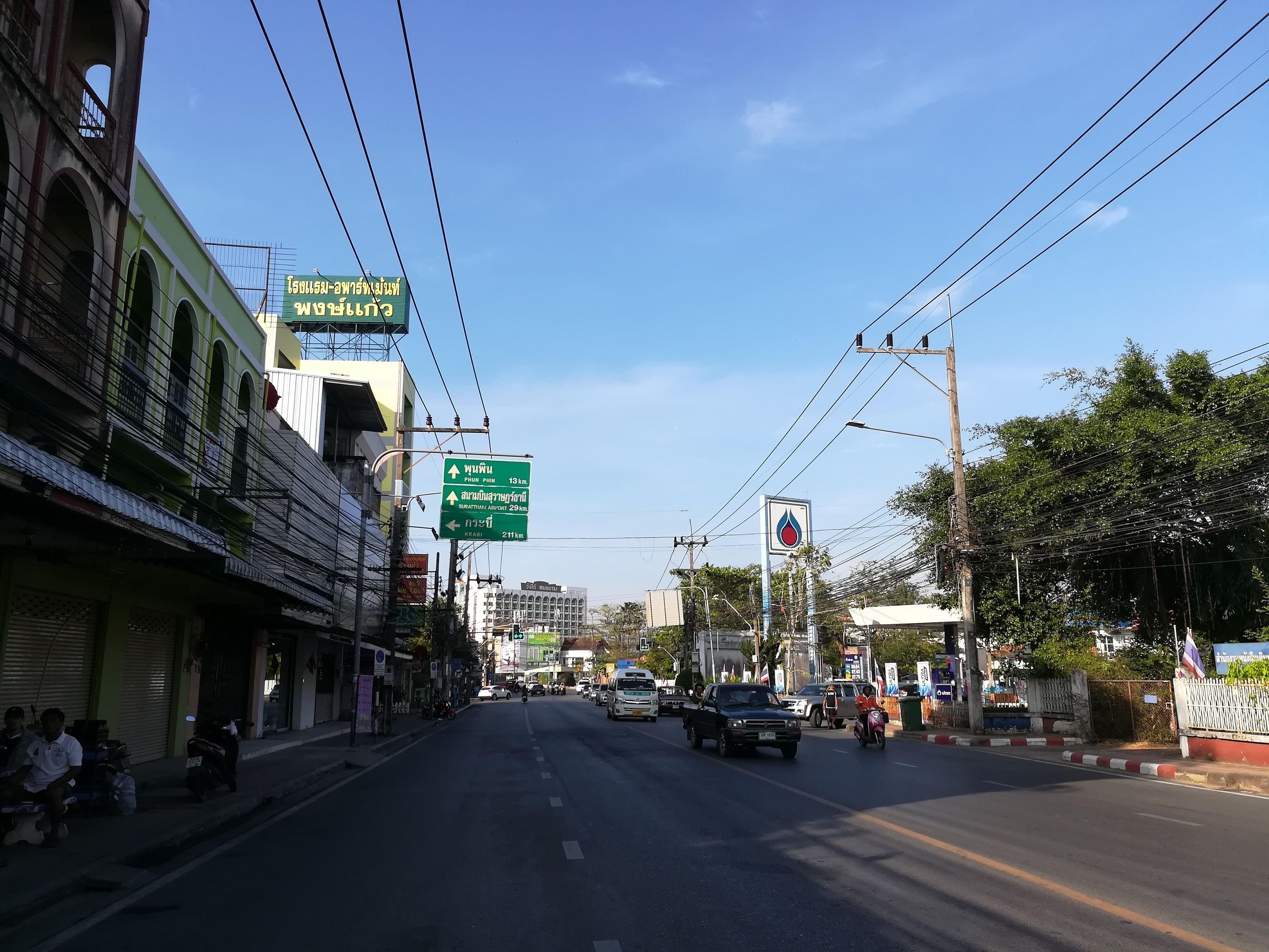 Una calle con edificios, cielo despejado y señalización.