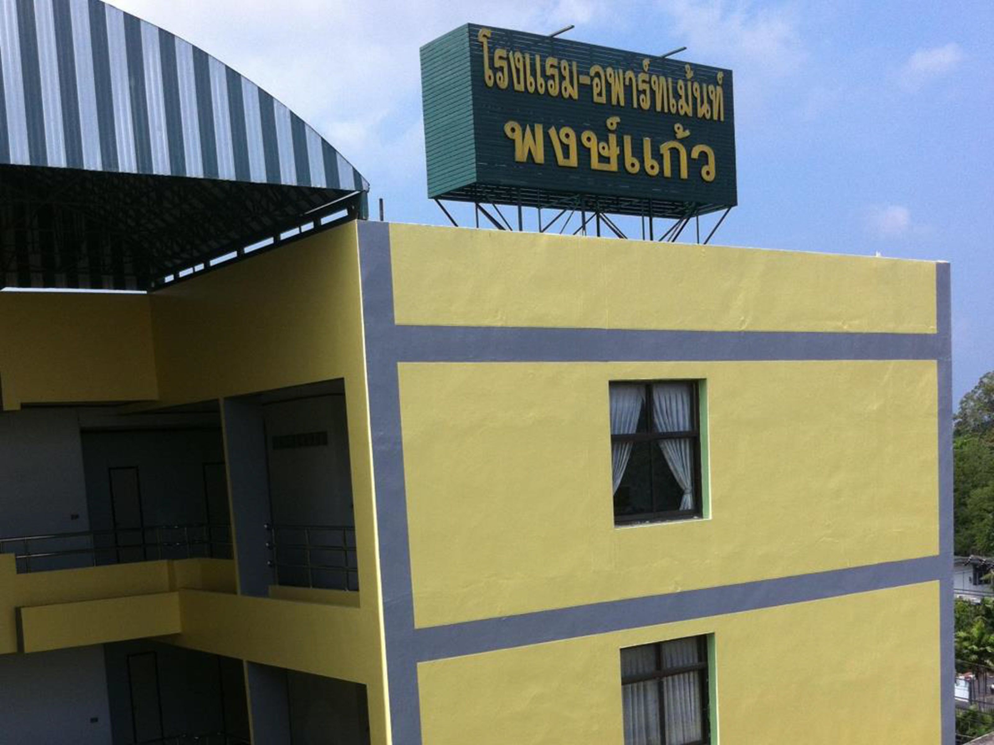 A yellow building with a sign in a foreign language.