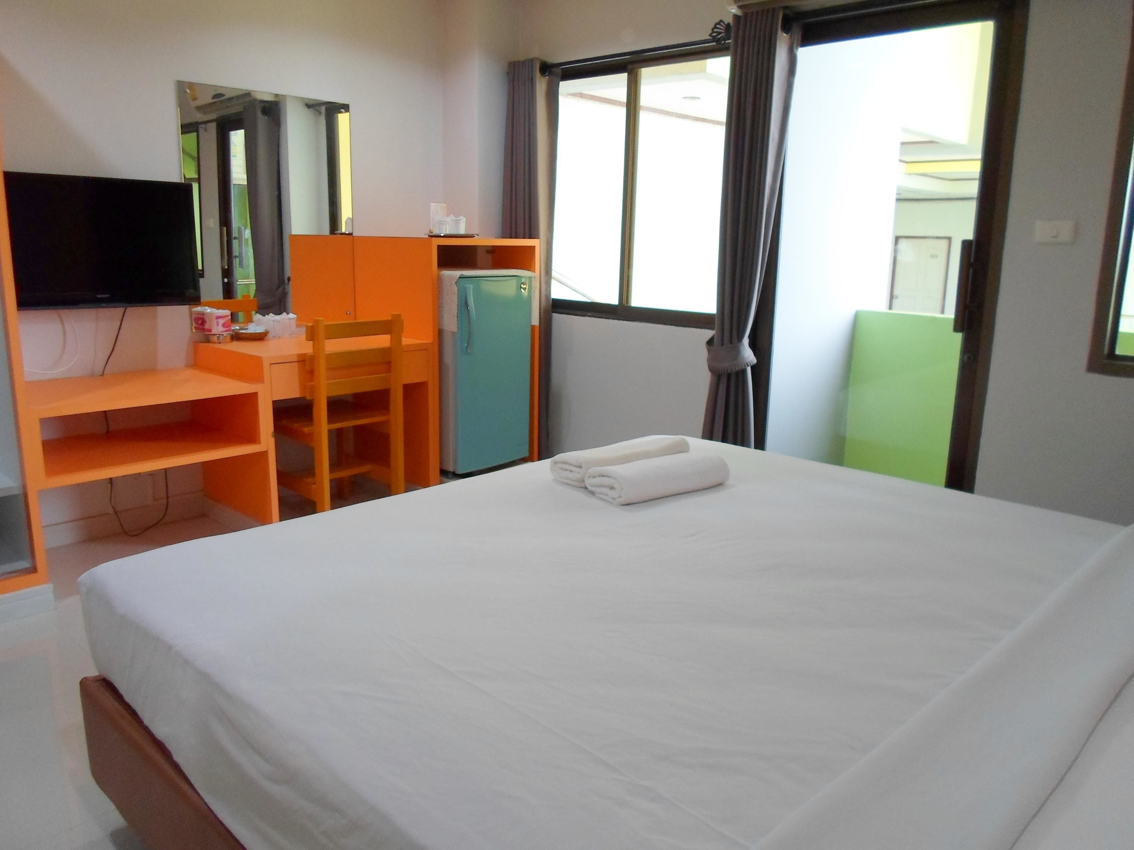 Une chambre d’hôtel avec un lit, un bureau, une chaise, une télévision et une fenêtre.