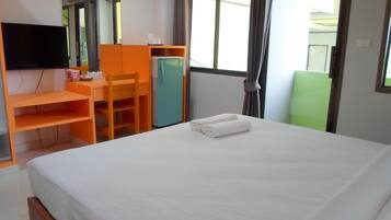 Une chambre d’hôtel avec un lit, un bureau, une chaise, une télévision et une fenêtre.