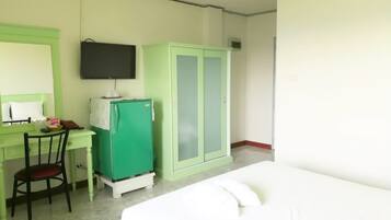 Una habitación con cama, escritorio y silla, televisor y armario.