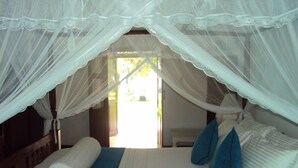 A bed with a canopy, a blue pillow, and a white pillow. - Arunalu Lake Front (Koggala)